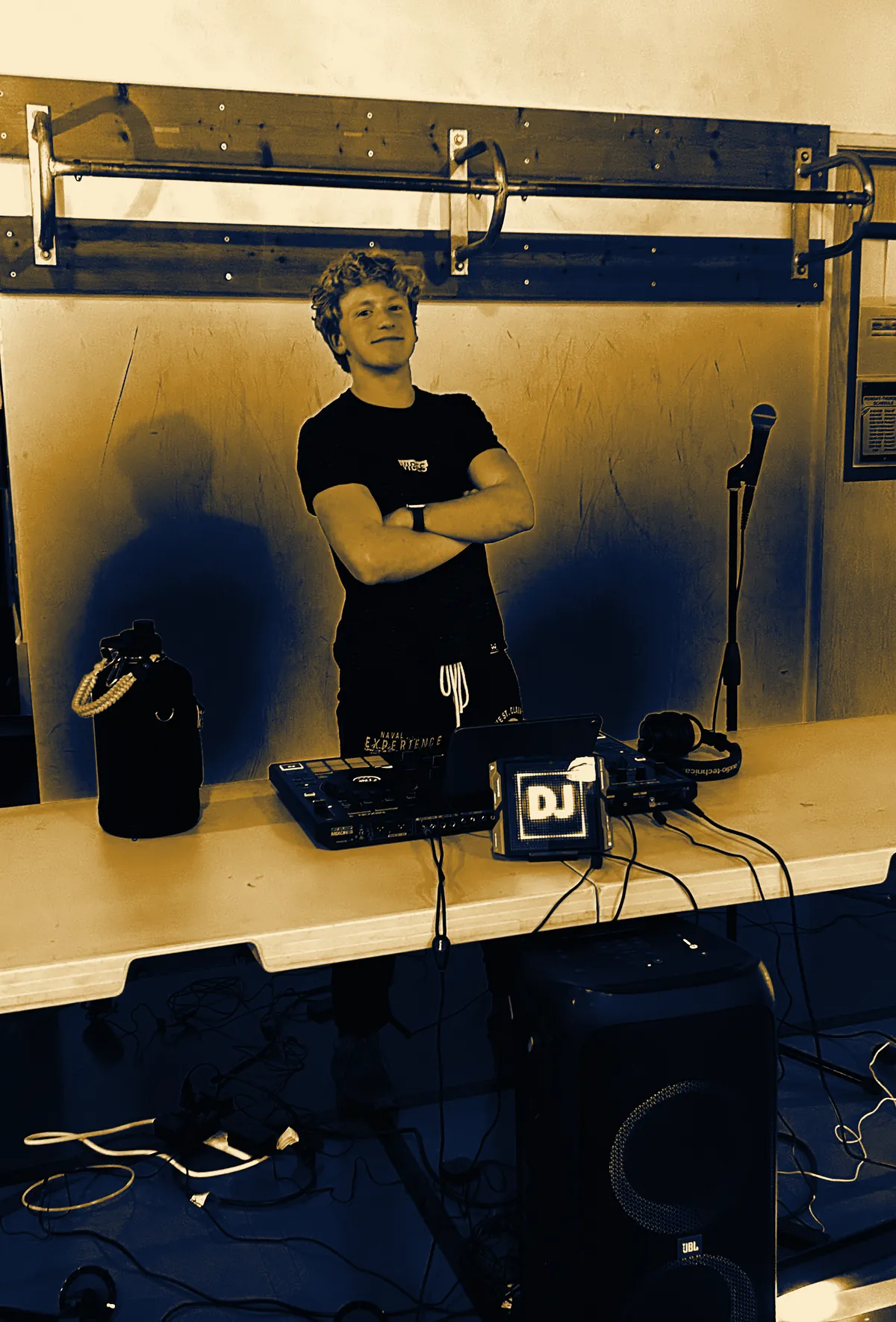 DJ Zion, founder of ZION Entertainment, arms crossed behind his DJ table