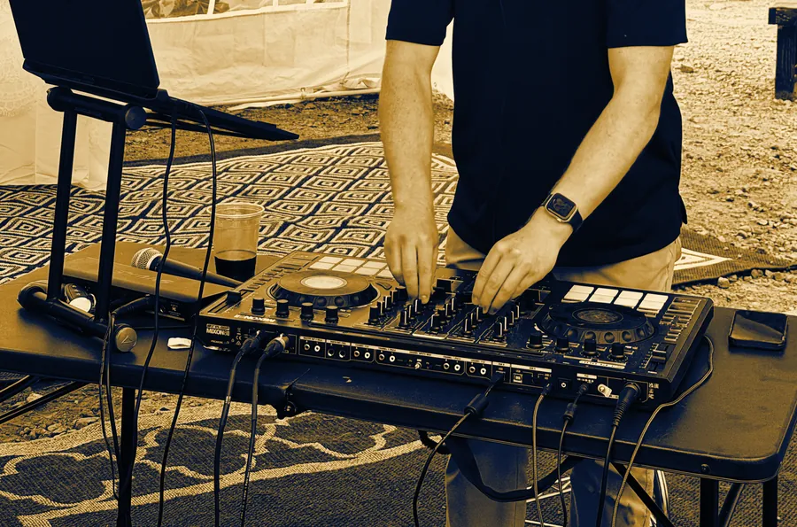 DJ Zion at the Mixon 8 Pro controller under a wedding tent